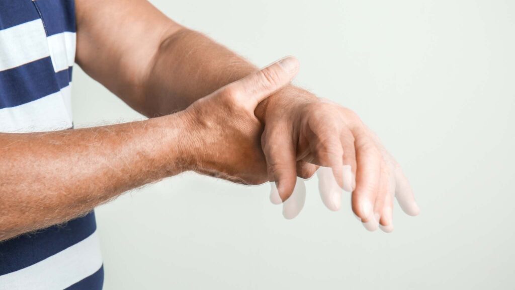 Homem idoso com mal de Parkinson com dificuldades de controlar movimentos da mão (crédito da imagem: Pixelshot/ Canva Pro)