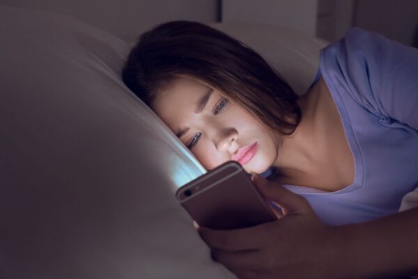Luz azul do celular atrasa o sono e afeta a melatonina. (Foto: Pixelshot via Canva)