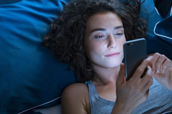 Celular perto da cama pode atrasar o início do sono. (Foto: Rido via Canva)