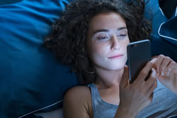 Celular perto da cama pode atrasar o início do sono. (Foto: Rido via Canva)