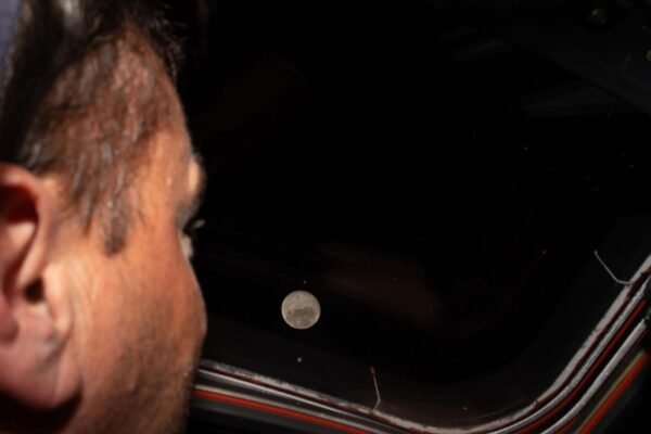 Reid Wiseman observa a Lua pela janela da Orion antes do sobrevoo lunar em 2026 (Imagem: NASA)